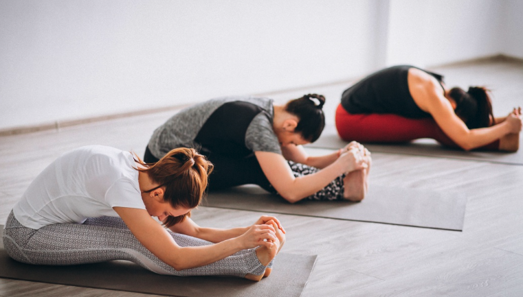 trois femmes position penchee avant cours yoga